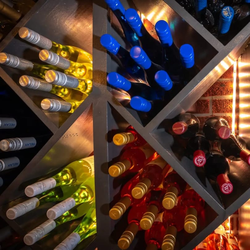 A wine rack filled with various bottles of Favio's Trattoria's red, white, and rosé wines.